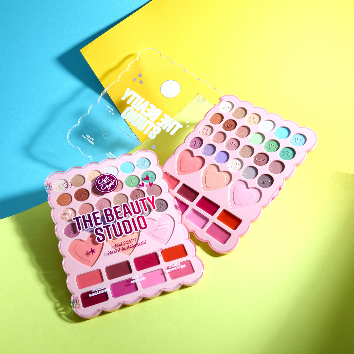 Two makeup palettes on a bright yellow and blue background. One palette is open, showing various shades, while the other is closed.