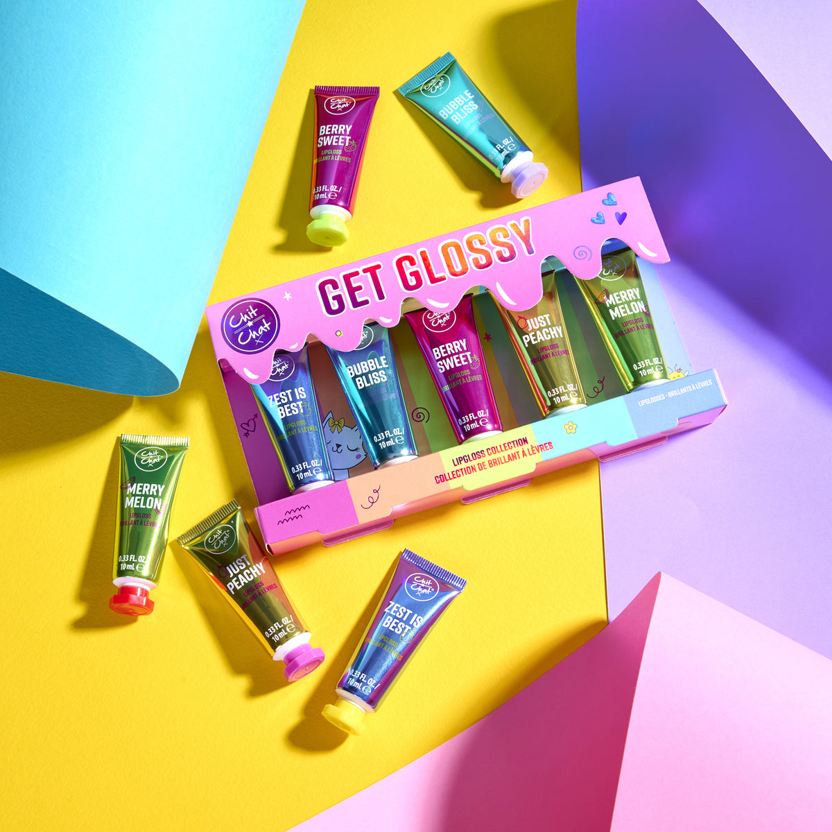 A lipgloss collection set by Chit Chat, featuring a pink box labeled 'GET GLOSSY' with five lipgloss tubes inside, plus five individual tubes placed around it on a bright geometric background, for aesthetic visual purposes.