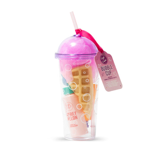 A clear plastic beverage cup with a straw, filled with a waffle-shaped sponge, and a pink shower puff, two bottled bath products and a flower shaped bath fizzer. A pink hangtag reading 'Bubble Cup' is attached to the side.