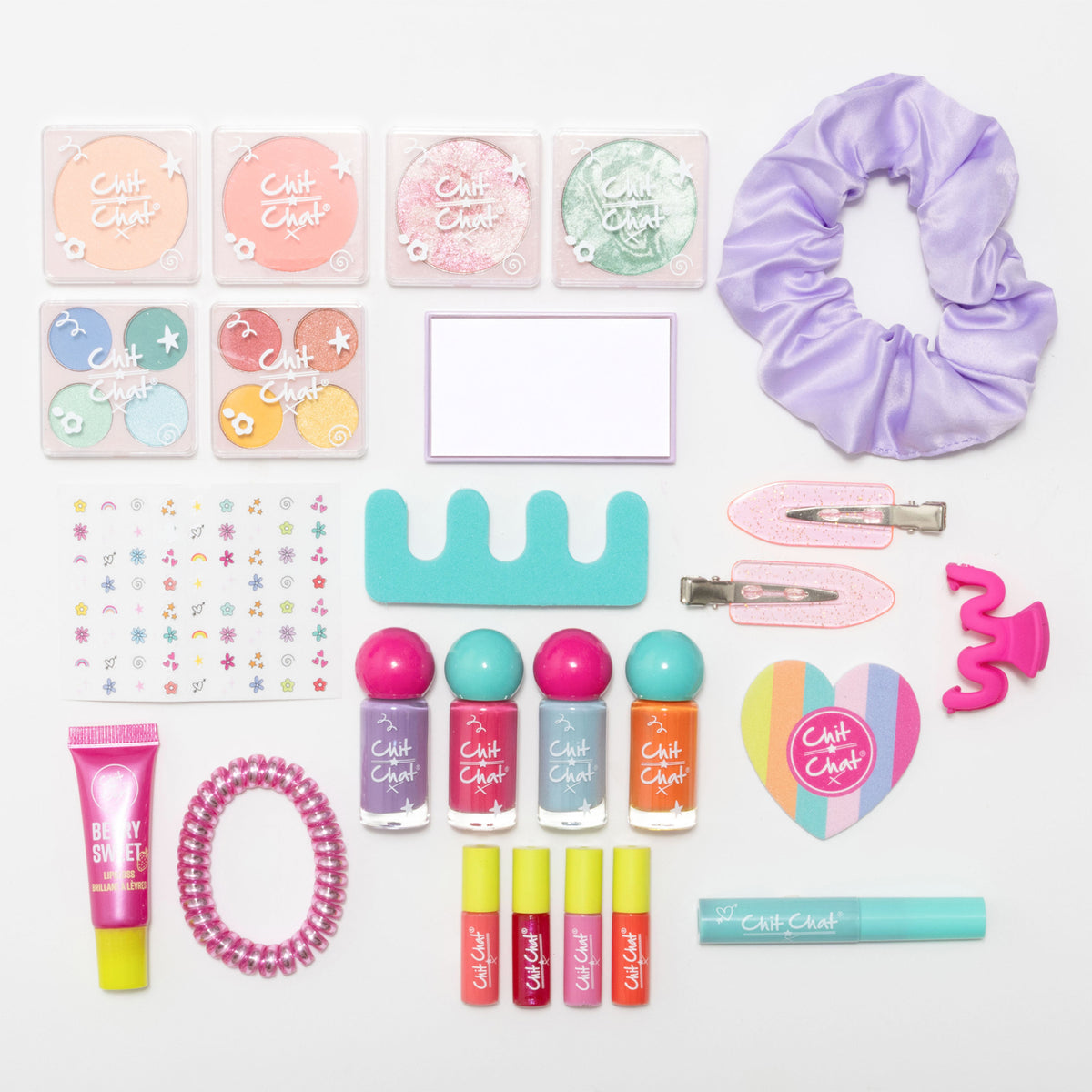 All cosmetics arranged on a white background, featuring a lavender satin scrunchie, pink glitter hair clips, a pink spiral bobble, a hot pink mini claw clip, a mirror, four nail polish bottles, four lip glosses, a tube of lipgloss, a sheet of nail stickers, two  blushers, two highlighters, two eyeshadow palettes, toe separators, a heart shaped nail file, a mascara.
