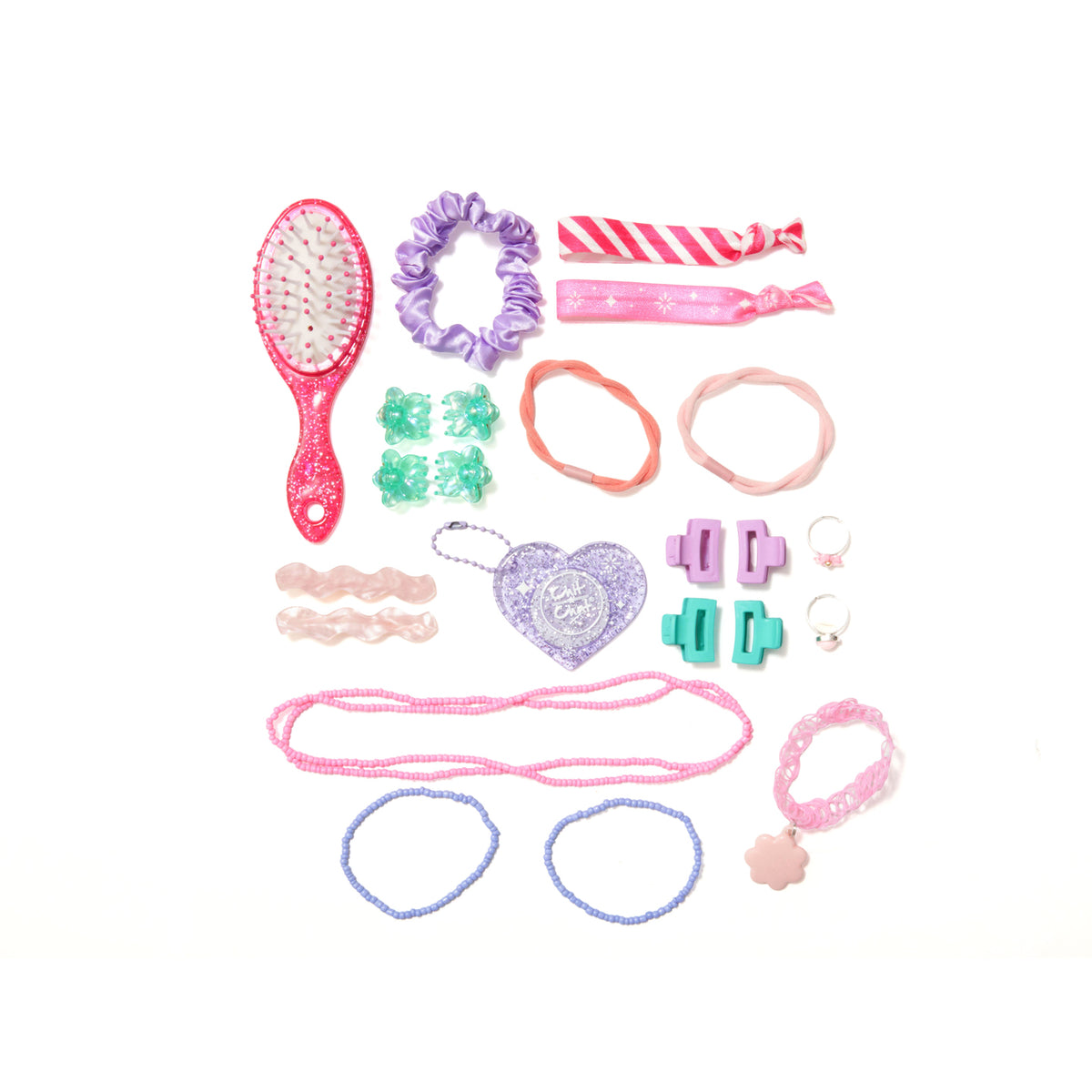 A flat lay of a children's hair accessory set on a white background, including a pink glitter hairbrush, purple scrunchie, elastic hair bands, floral hair clips, mini claw clips, rings, beaded bracelet, beaded necklace, floral bracelet, wavy slide clips, fabric wrist bands and a heart-shaped charm.