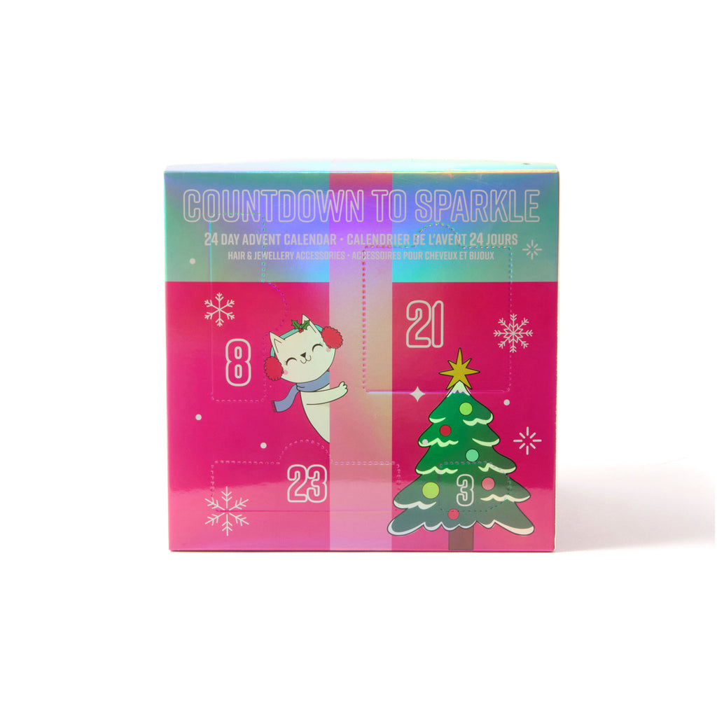 A Christmas advent calendar box with a bright pink front panel, numbered doors, a cartoon cat in red earmuffs, and a decorated Christmas tree. The top has a pastel gradient and the text reads 'COUNTDOWN TO SPARKLE'.