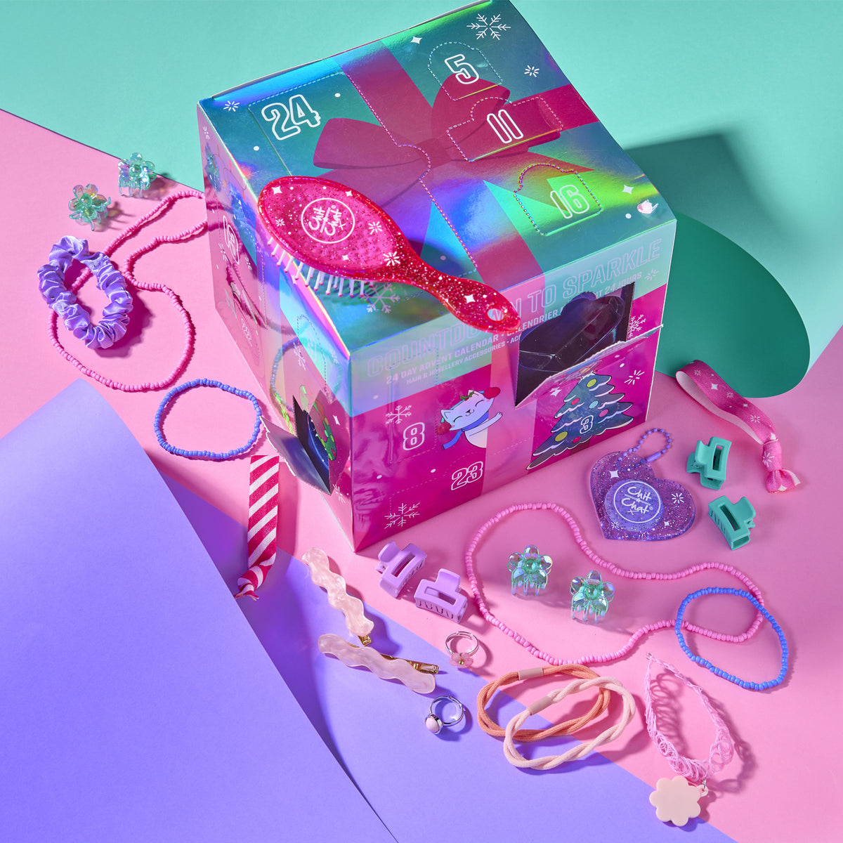 A colourful advent-style gift box with numbered doors and a pink bow, surrounded by pastel hair accessories and small jewellery pieces on a pink, purple, and mint background.